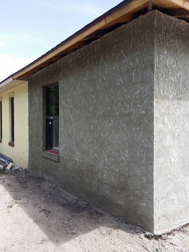 The same corner finished in stucco, tying into the existing house wall