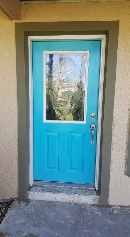 Finished wall around a bright turquoise front door, the repair blended into the existing texture