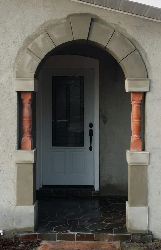 Same entry refinished in smooth stucco with stone-look arch surround
