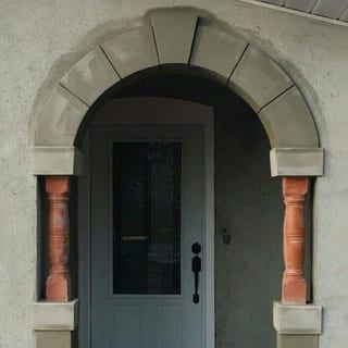 Close-up of the finished arch surround, its keystones and the terracotta columns either side of the door