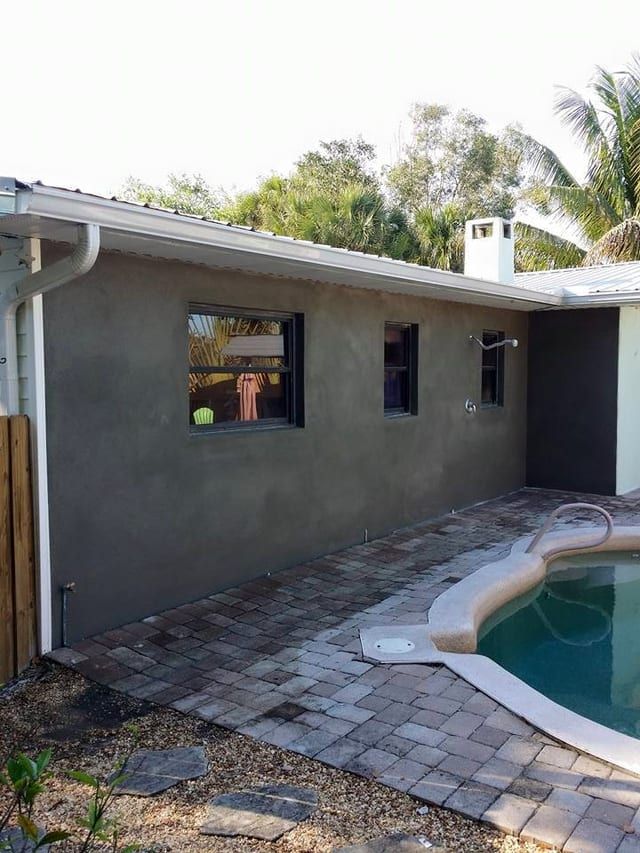 Same home re-stucco-ed and recoloured to warm beige with maroon door