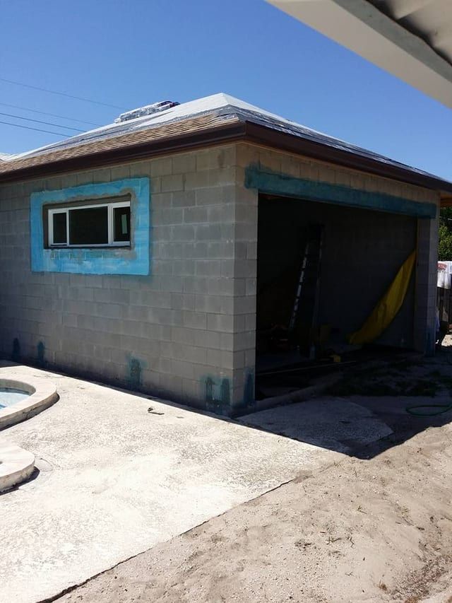 Bare block addition beside a pool deck with the window opening taped off