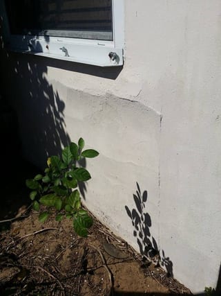 Horizontal crack under a white window before repair