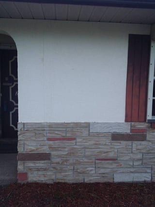 The same wall re-finished to an even white, cut in clean along the top of the stone