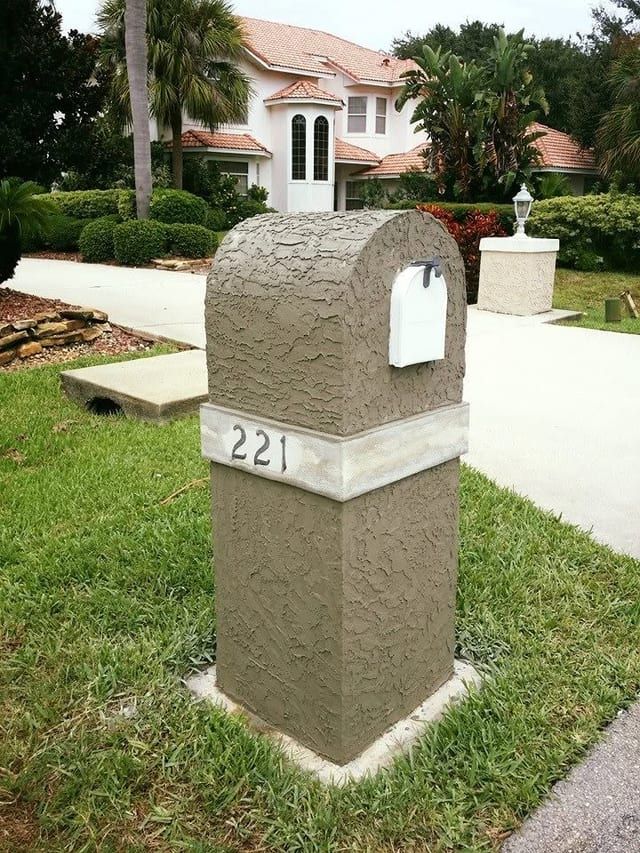 Finished stucco mailbox column with the house number set into the face