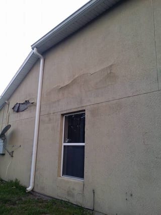 Bulging stucco pulling away from a wall in a long horizontal band